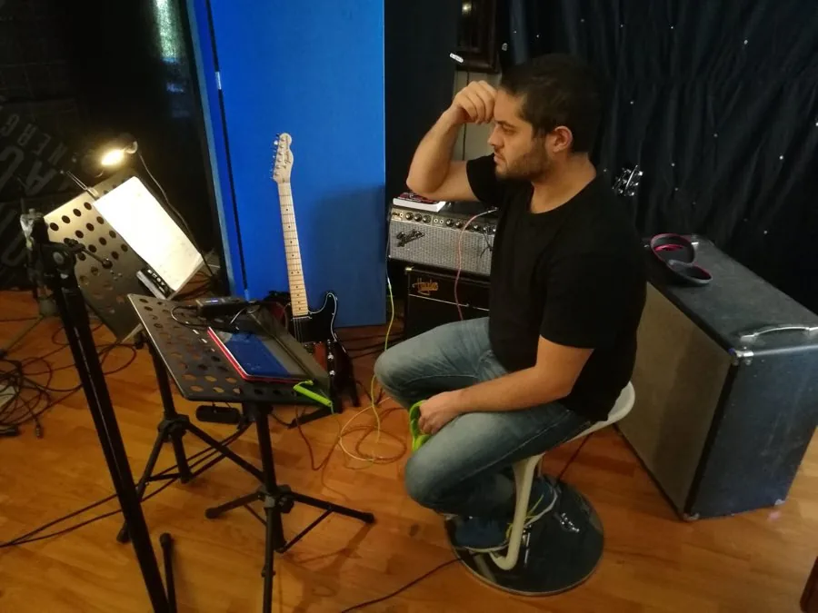 Umberto at the desk in the live room, listening back beside a Telecaster and amp