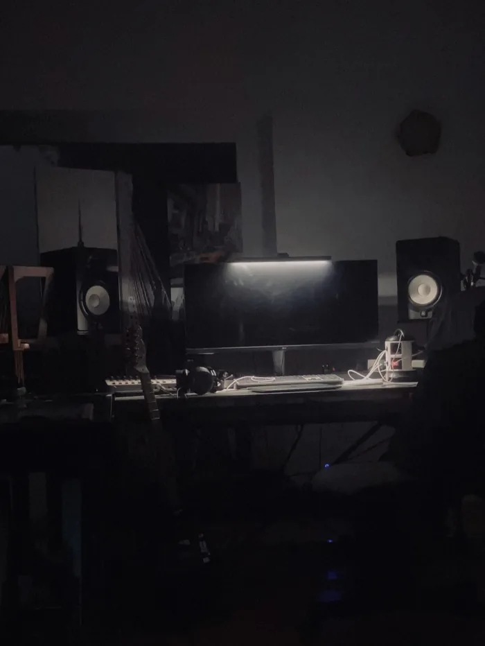 The studio at night, monitors lit, the room dark around them